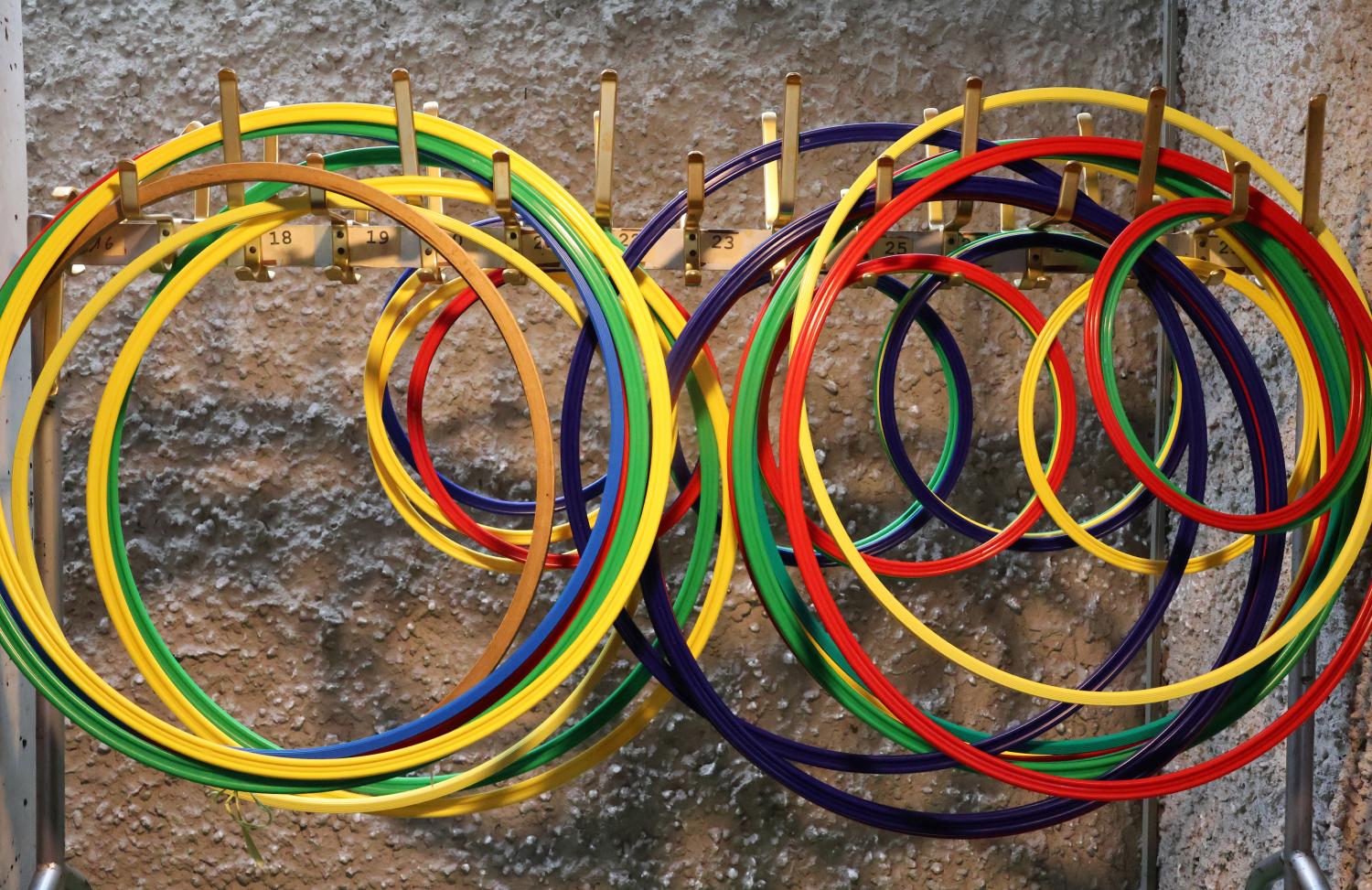Das Bild zeigt viele bunte unterschiedlich große Gymnastikringe an einem Ständer