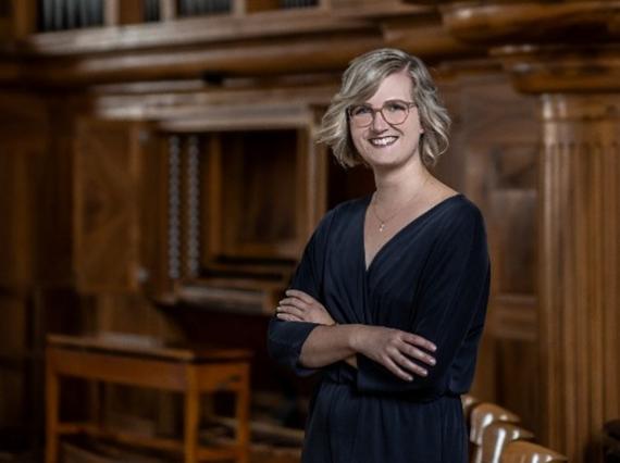 Das Bild zeigt die Organistin Carla Braun vor der Orgel in der Pauluskirche Bad Kreuznach