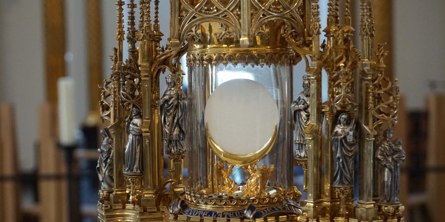 Vergoldete Monstranz mit Hostie, umgeben von Heiligenfiguren in einer Kirche. (c) Daniel Giessmann In: Pfarrbriefservice.de Vergoldete Monstranz mit Hostie, umgeben von Heiligenfiguren in einer Kirche.